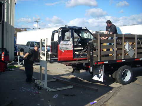 1992 Ford Ranger - A truck cab is being loaded onto a flatbed truck with the help of a forklift.