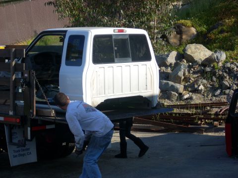 1992 Ford Ranger - A white pickup truck cab is being loaded onto a flatbed trailer by a man.