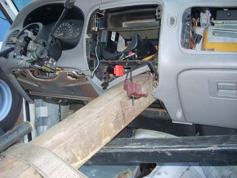 1992 Ford Ranger - The dashboard of a vehicle is disassembled, with a wooden beam supporting the structure.