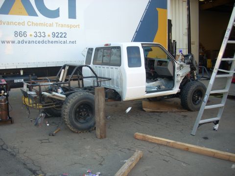 1992 Ford Ranger - A 1992 Ford Ranger is shown in a workshop, stripped down to its chassis and cab, with a roll cage installed.