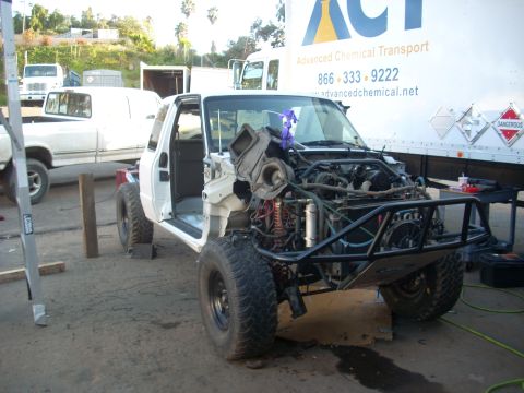 1992 Ford Ranger - A white pickup truck is undergoing extensive repairs, with its front end completely disassembled.