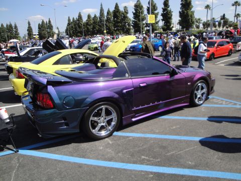 1993 Ford Taurus - A custom convertible with a unique purple and blue paint job is displayed at a car show with other vehicles.