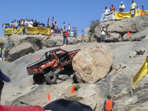 1979 Ford Bronco - A custom off-road vehicle attempts to climb a massive boulder during an event.