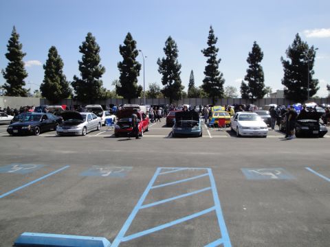 1993 Ford Taurus - A car show or meet-up with many vehicles parked in an outdoor lot.