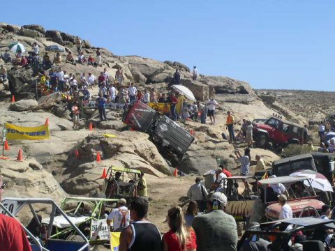 1979 Ford Bronco - Spectators watch as off-road vehicles navigate a challenging rocky course, with one vehicle tipped over.