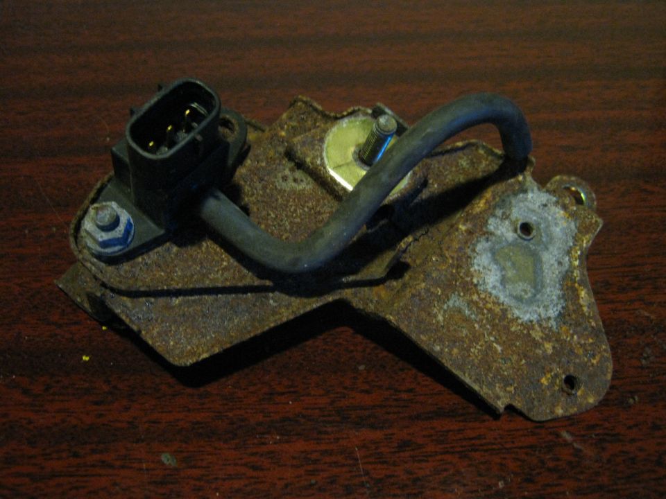 Rusty sensor or actuator on a metal bracket with wiring connector