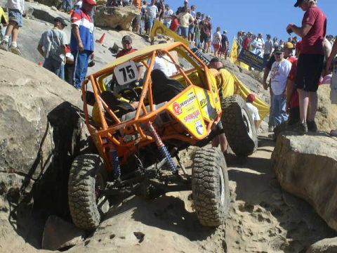 1979 Ford Bronco - An off-road buggy tackles a challenging rocky course with spectators watching.