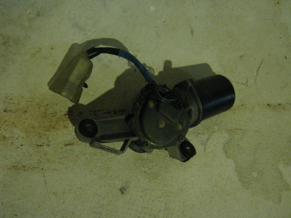 Windshield wiper motor with wiring connector on a concrete floor