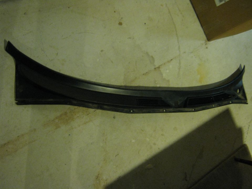 Black plastic windshield cowl vent panel on the floor