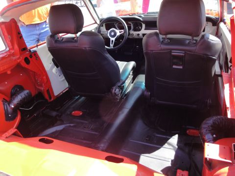 1993 Ford Taurus - The interior of a car shows black seats and red trim, with a view towards the dashboard and steering wheel.