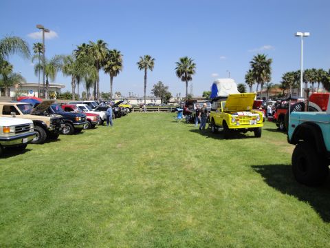 1993 Ford Taurus - Several vehicles are parked on a grassy field under a clear blue sky.