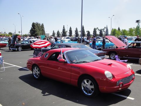 1993 Ford Taurus - A red 2002 Ford Thunderbird convertible is parked at a car show with other vehicles.