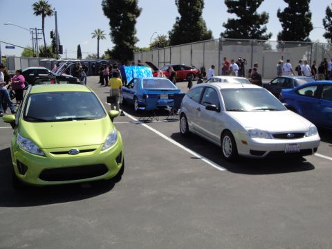 1993 Ford Taurus - A silver Ford Focus hatchback is parked at an outdoor car show.