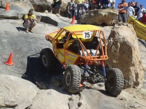 1979 Ford Bronco - A custom off-road buggy navigates a rocky obstacle course with spectators watching.