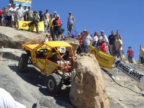 1979 Ford Bronco - A custom-built off-road buggy navigates a steep, rocky incline during a competition.