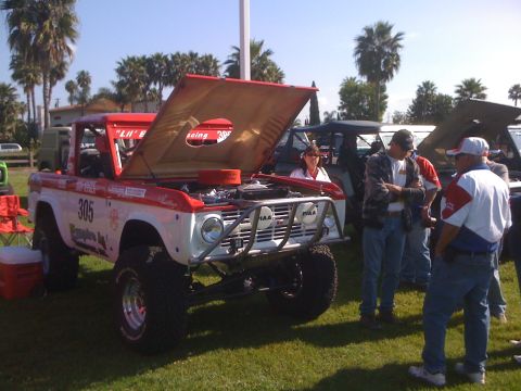 1996 Ford C-350 (Centurion Conversions) - Modified off-road truck on display with hood open, people gathered around.