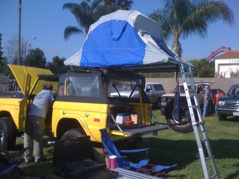 1996 Ford C-350 (Centurion Conversions) - A yellow 1978 Ford Bronco is set up with a rooftop tent, ready for an outdoor adventure.