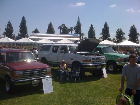 1996 Ford C-350 (Centurion Conversions) - A white 1996 Ford C-350 Centurion Conversions SUV is displayed with its hood open at an outdoor event.