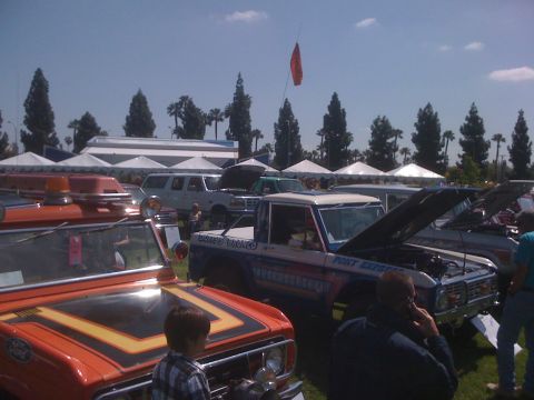1996 Ford C-350 (Centurion Conversions) - Several vehicles are on display at an outdoor event under a clear sky.