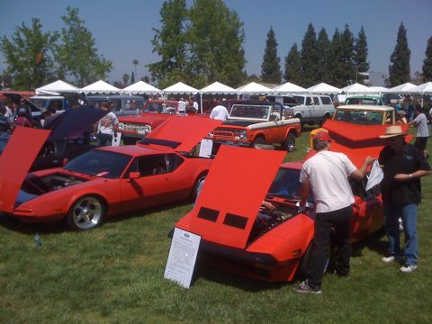 1996 Ford C-350 (Centurion Conversions) - Several cars are displayed at an outdoor event with tents in the background.