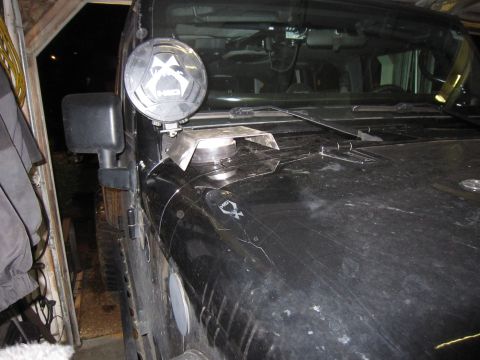 2008 Jeep Wrangler - Close-up of the driver's side cowl of a black Jeep Wrangler with a round covered off-road driving light mounted on a bare aluminum bracket…