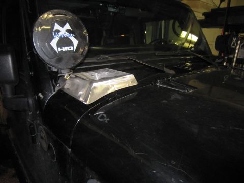 2008 Jeep Wrangler - Cowl-mounted round HID off-road light on a black Jeep Wrangler, wearing a black Vision X 'HID' cover, with a polished bare-metal hood-scoop…