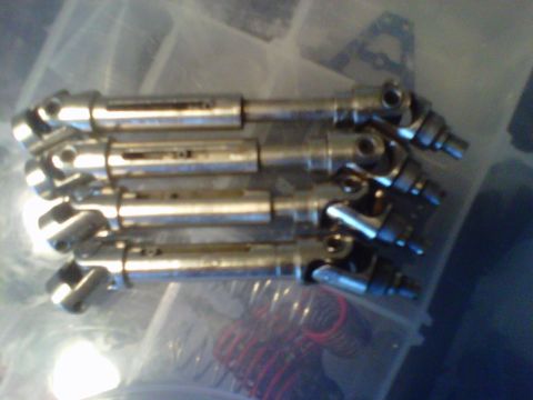 2011 Ford 427 - A collection of four drive shafts, likely for an RC car or similar hobbyist vehicle, are neatly arranged in a container.