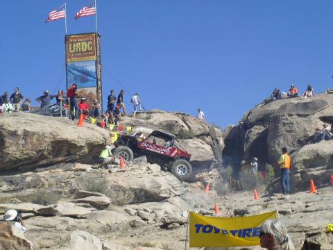 1979 Ford Bronco - An off-road vehicle navigates a challenging rocky course under a clear blue sky.