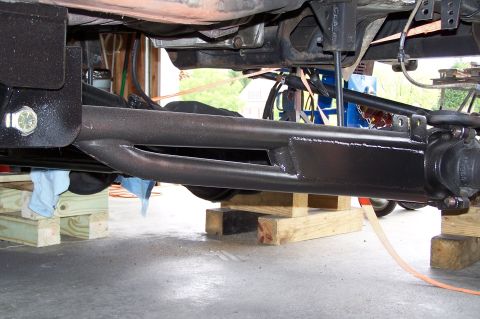 2000 Ford F-150 - The undercarriage of a 2000 Ford F-150 shows suspension components and is supported by wooden blocks.