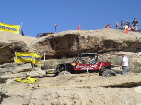 1979 Ford Bronco - Off-road vehicles compete on a rocky course under a clear blue sky.