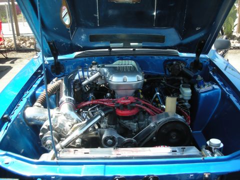 2004 Ford Crown Victoria - The engine bay of a blue car is open, revealing a supercharger and various engine components.