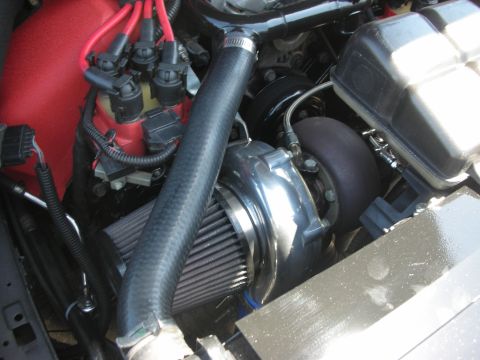 2004 Ford Crown Victoria - Close-up view of a modified engine bay a turbocharger and custom red distributor cap.