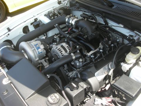 2004 Ford Crown Victoria - Close-up view of a modified engine bay, showing a supercharger and intake system.