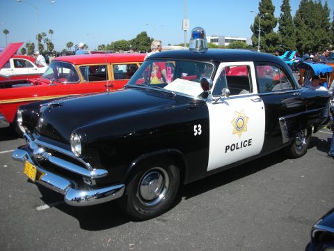 2004 Ford Crown Victoria - This vintage police car, likely a 1953 model, is on display at a car show.