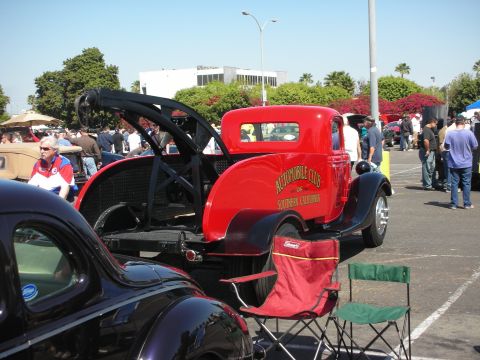 2004 Ford Crown Victoria - A vintage red tow truck with a prominent logo is displayed at a car show.