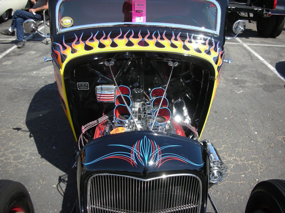 Hot rod with flames on hood, pinstripes on hood, and exposed engine