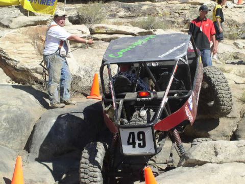 1979 Ford Bronco - A custom off-road buggy navigates a rocky obstacle course with spectators watching.