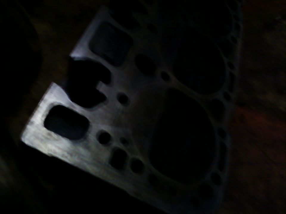 Engine cylinder head with multiple bolt holes and intake/exhaust ports