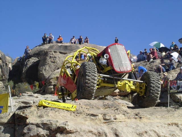 Yellow buggy with red grille on rocky terrain