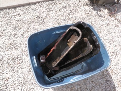 1982 Ford Bronco - Used oil pans soaking in a tub of water outdoors.