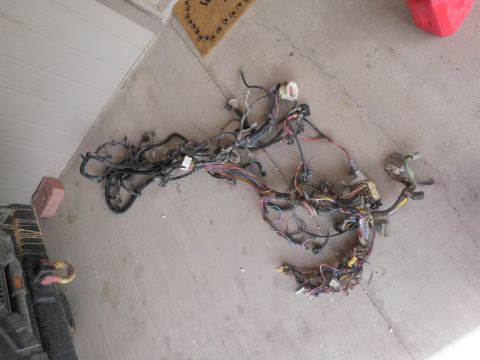 1982 Ford Bronco - A complex vehicle wiring harness is spread out on a concrete surface, showing many wires and connectors.