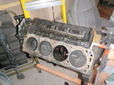 1982 Ford Bronco - Engine block with pistons visible inside cylinders, supported by an engine stand.