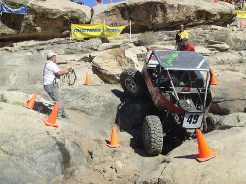 1979 Ford Bronco - Off-road buggy competes on a rocky course with orange cones marking the path.