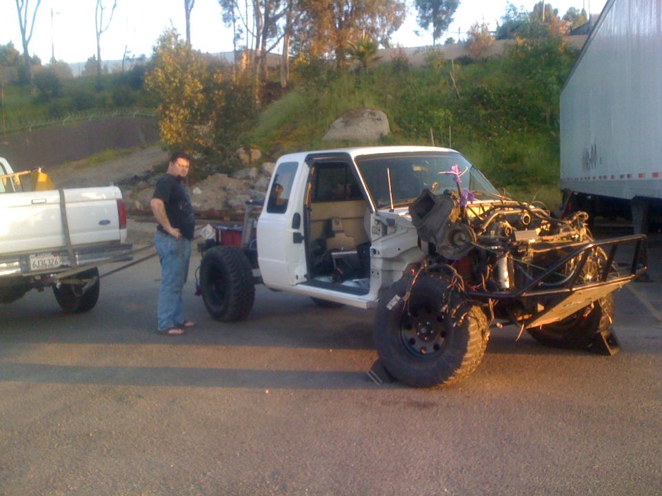1992 Ford Ranger truck with front end damage being towed by another truck