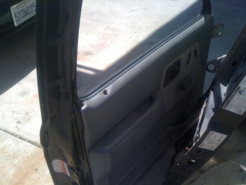 1992 Ford Ranger - Interior view of a truck door panel, showing the window frame and door handle. A license plate is visible in the background.