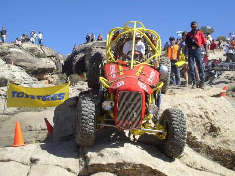 1979 Ford Bronco - A custom-built off-road buggy navigates a challenging rocky course with spectators observing.