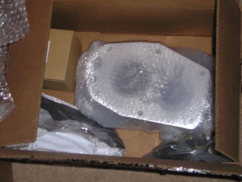 1990 Toyota Pickup/SR5 - A metal suspension part is seen inside a cardboard box, wrapped in protective bubble wrap.