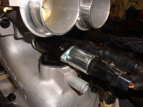 1989 Ford Bronco - Engine intake manifold with throttle body and sensor visible in a close-up view.