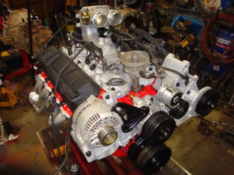 1989 Ford Bronco - Engine assembly with intake manifold, distributor, alternator, and pulleys is ready for installation.