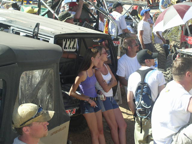 Several people stand near off-road vehicles, one with number 222 on the side